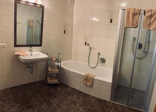 a bathroom with a tub and a sink and a shower at Appartements Samerhof - TOP 1 in Kaltenbach