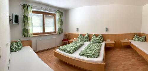 sypialnia z 2 łóżkami i zielonymi poduszkami w obiekcie Appartements Samerhof - TOP 1 w mieście Kaltenbach