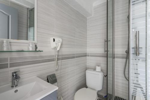 a bathroom with a toilet and a sink and a shower at Hotel Les Palmiers En Camargue in Saintes-Maries-de-la-Mer