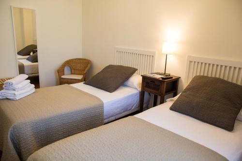 a hotel room with two beds and a table with a lamp at Posada de Suesa in Suesa