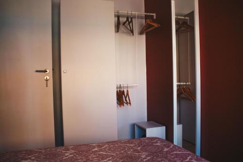 um quarto com uma cama e um armário com cabides em Apartamento Torreão na Póvoa do Varzim
