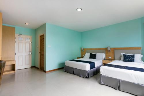 two beds in a room with blue walls at Golden Beach Boutique Resort in Prachuap Khiri Khan