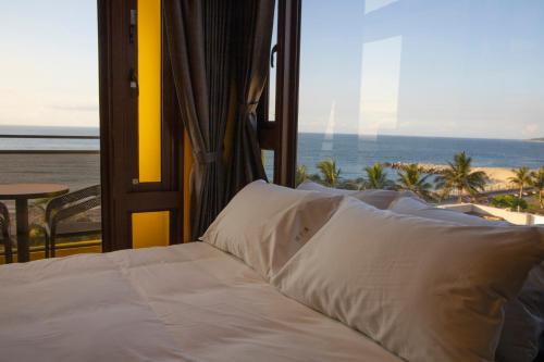 a bed in a room with a view of the beach at 花蓮諾丁漢海景民宿 Nottingham Seaview Inn in Hualien City