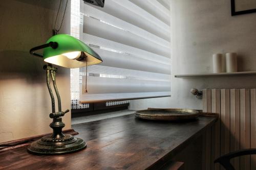 a green lamp sitting on top of a wooden table at Villa Belvedere Langhe in Belvedere Langhe