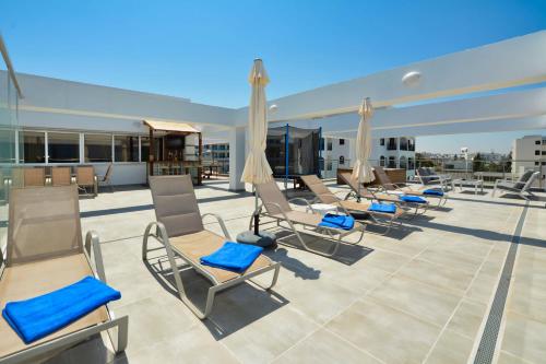 a row of chairs on the roof of a building at Seafront Protaras Apartments in Protaras