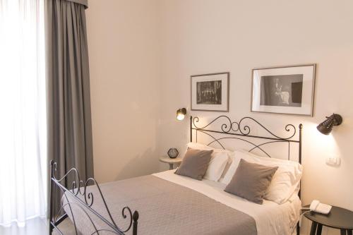 a bedroom with a large bed with white sheets at Liberty Palace in Milazzo