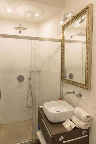 a bathroom with a sink and a shower with a mirror at Liberty Palace in Milazzo