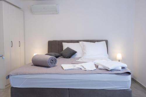ein Bett mit weißen Kissen und Handtüchern darauf in der Unterkunft Apartments Sky in Vodice