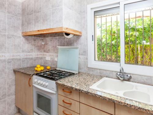 cocina con fogones, fregadero y ventana en Apartment Villa Cordoba-1 by Interhome, en Port de la Selva