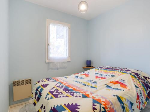 une chambre avec un lit avec une couette colorée dans l'établissement Apartment Fleur Marine-27 by Interhome, à Cabourg