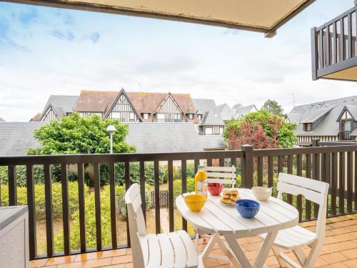 une table blanche et des chaises sur un balcon dans l'établissement Apartment Fleur Marine-27 by Interhome, à Cabourg