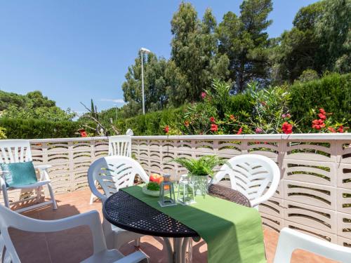 una mesa y sillas en un patio con flores en Holiday Home Coqueto by Interhome, en Riumar