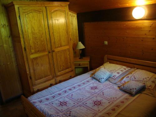サン・ジェルヴェ・レ・バンにあるChalet Le Paddockのベッドと木製のキャビネットのある寝室