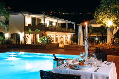 a table with a plate of food next to a swimming pool at Cuore del Cilento Relais&Retreat in Castellabate
