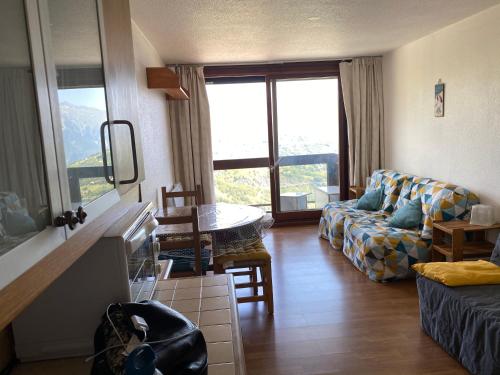 a living room with a couch and a table at Studio 22m² balcon Pégase Phenix Le Corbier in Le Corbier