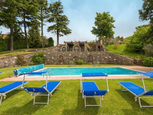 a pool with blue lounge chairs and a house at Villa Vista da Rocca di Papa-2 by Interhome in Rocca di Papa