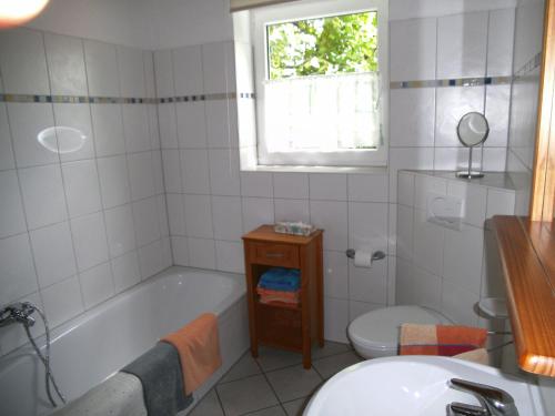 a bathroom with a tub and a toilet and a sink at Ferienhaus Kettler I in Muhr amSee