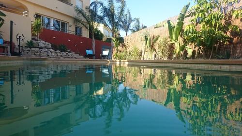 a pool of water in front of a building at Guesthouse en Coveta fumà- El Campello in El Campello
