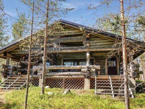 a log cabin with a porch in the woods at Holiday Home Kulpakko 2 by Interhome in Tiainen