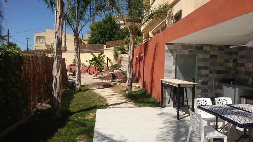 a patio with a table and chairs next to a building at Guesthouse en Coveta fumà- El Campello in El Campello
