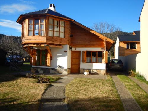 a wooden house with a car parked in front of it at Cabaña en el Centro in San Martín de los Andes