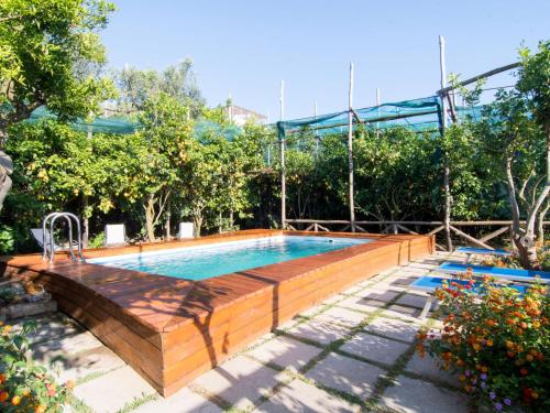 a swimming pool with a wooden fence around it at Holiday Home Emi by Interhome in Massa Lubrense