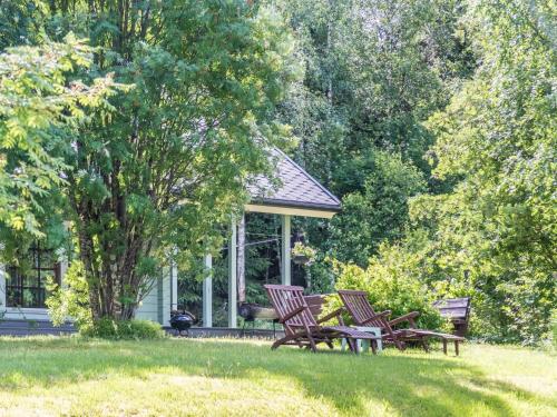 a gazebo with three chairs in a park at Holiday Home Kuukatti by Interhome in Lahdenperä