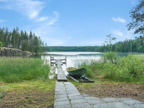 un barco sentado en un muelle junto a un lago en Holiday Home Saimaanhovi by Interhome, en Hauhola