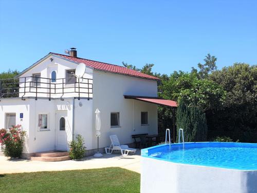 a villa with a swimming pool in front of a house at Holiday Home Martina by Interhome in Valdebek