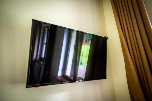 einen Flachbild-TV, der an einer Wand hängt in der Unterkunft Явір Резорт in Starychi