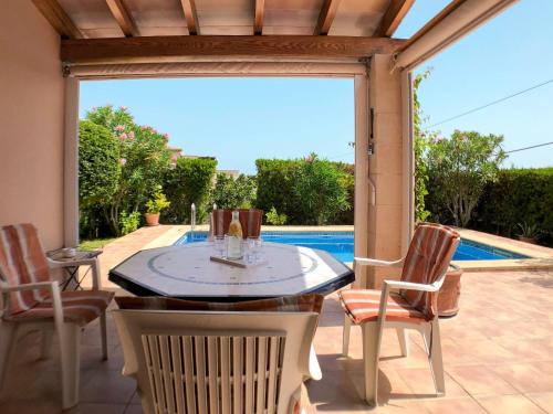 une terrasse avec une table, des chaises et une piscine dans l'établissement Holiday Home Schnuffi - PCN155 by Interhome, à Porto Cristo