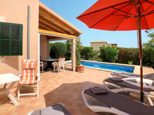 a patio with a table and an umbrella and a pool at Holiday Home Schnuffi - PCN155 by Interhome in Porto Cristo