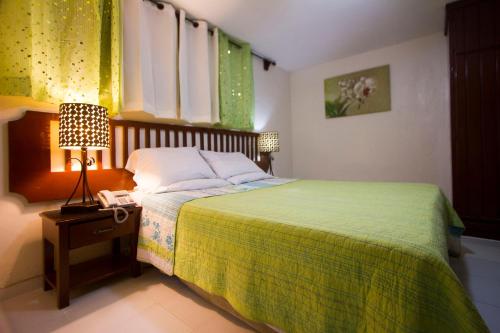 a bedroom with a bed with a phone and a lamp at Ideal Villa Hotel in Port-au-Prince