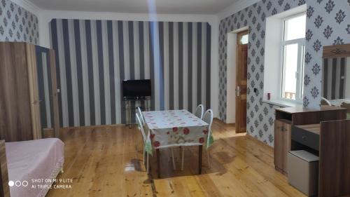 a living room with a table and a television at Qabala Villa House Samir in Gabala