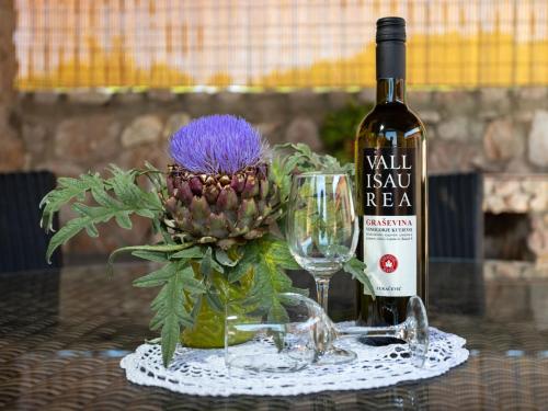 a bottle of wine next to a glass and a flower at Holiday Home Ana by Interhome in Šilo