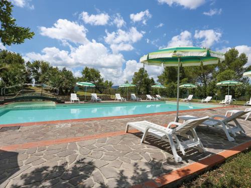 una piscina con sedie e ombrellone accanto all'aviatore di Apartment La Carraia - TER100 by Interhome a Laiatico