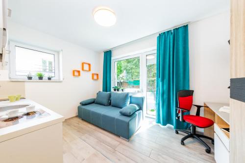 a living room with a blue couch and a red chair at HomeKoko Apartments in Katowice