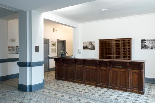 a large room with a wooden counter and a column at Le Gérémoy in Vittel