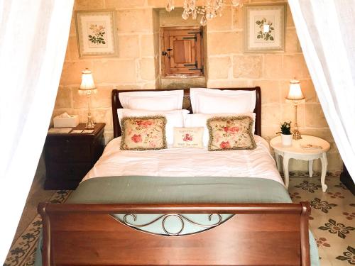 um quarto com uma cama grande e 2 almofadas em L'Gharix Temple Retreat em Xaghra