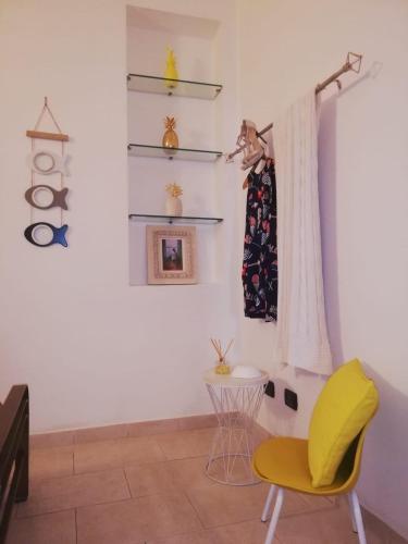 a room with a yellow chair and a table at Apartments Tellaro in Tellaro