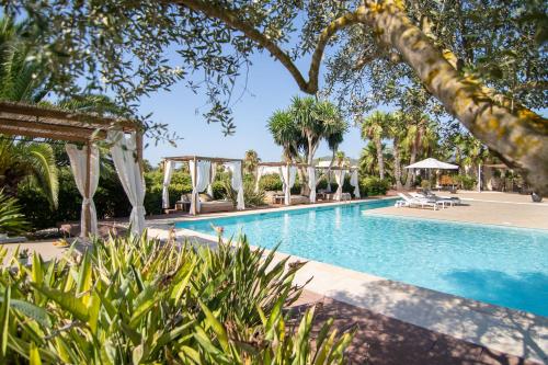 a pool at a resort with trees and chairs at Can Jaume by Ocean Drive in Ibiza Town