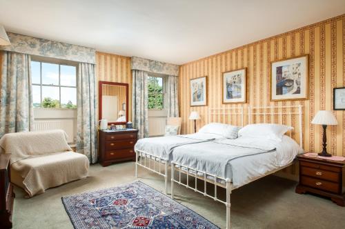 a bedroom with a bed and a chair at 95 Sydney Place B&B in Bath