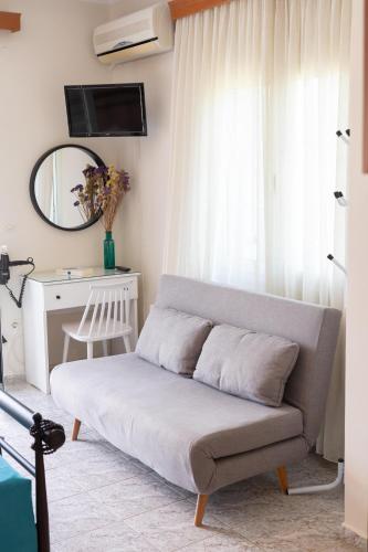 a couch in a living room with a mirror at Pavlatos Apartments & Studios in Sami
