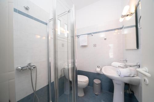 e bagno con doccia, servizi igienici e lavandino. di Pavlatos Apartments & Studios a Sami