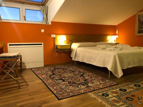 1 dormitorio con 1 cama con paredes de color naranja y alfombra en Villa Dell' Artista - Villa Anna, en Santarcangelo di Romagna