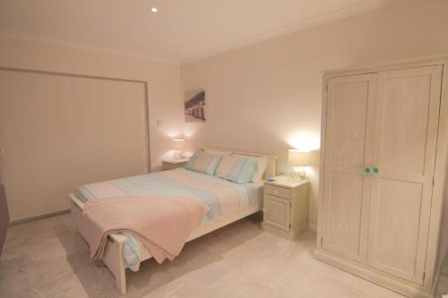 a small bedroom with a bed and two lamps at Ocean Reef Vista in Perth