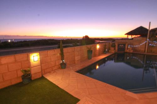 a swimming pool in a backyard at dusk at Ocean Reef Vista in Perth