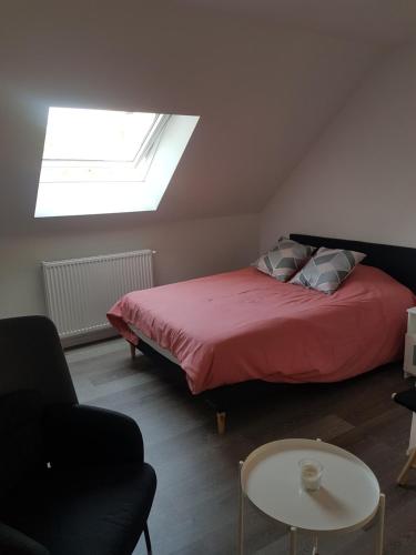Un dormitorio con una cama con una manta roja y una ventana. en STUDIO NEUF CENTRE VILLE, en Bourges