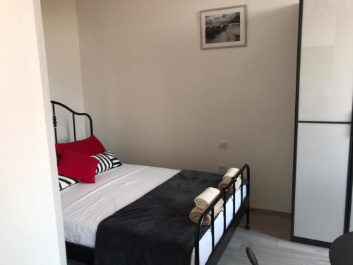 Dormitorio pequeño con cama con sábanas rojas y negras en STUDIO APARTMANI PAOLA en Rijeka