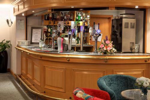 a bar in a room with a counter and chairs at Best Western Plus Bentley Hotel in Lincoln